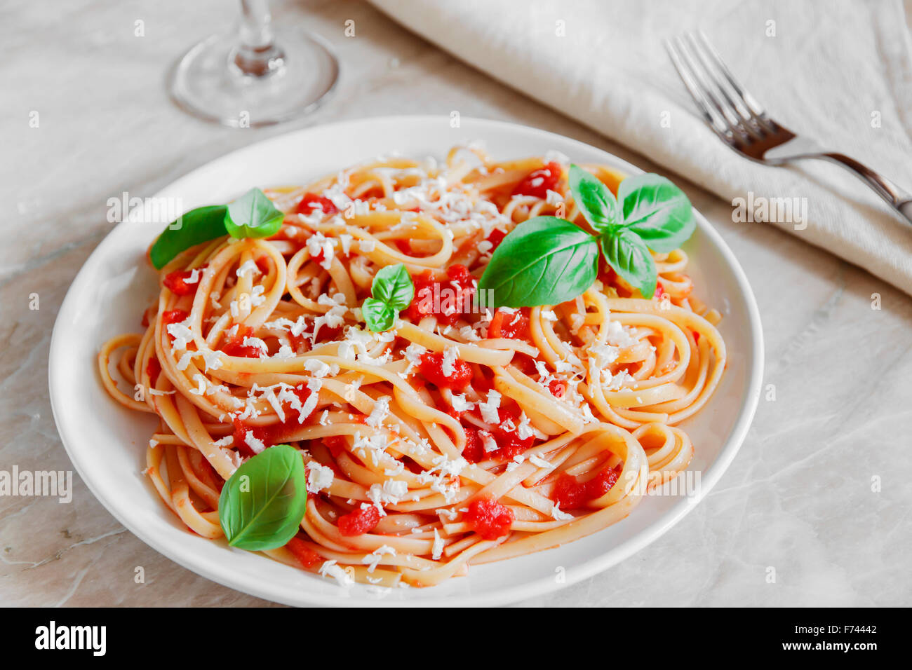 Linguine pasta in tomato sauce and cheese on a plate Stock Photo