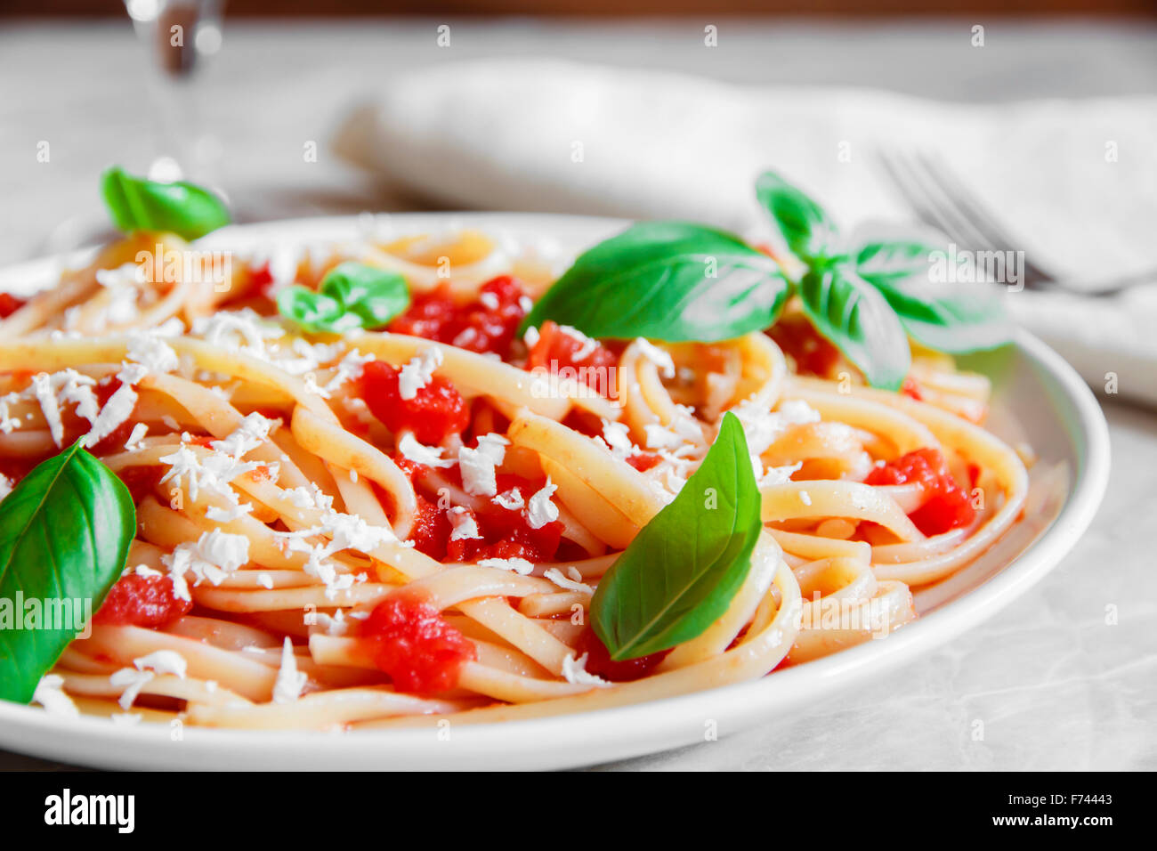 Linguine pasta in tomato sauce and cheese on a plate Stock Photo