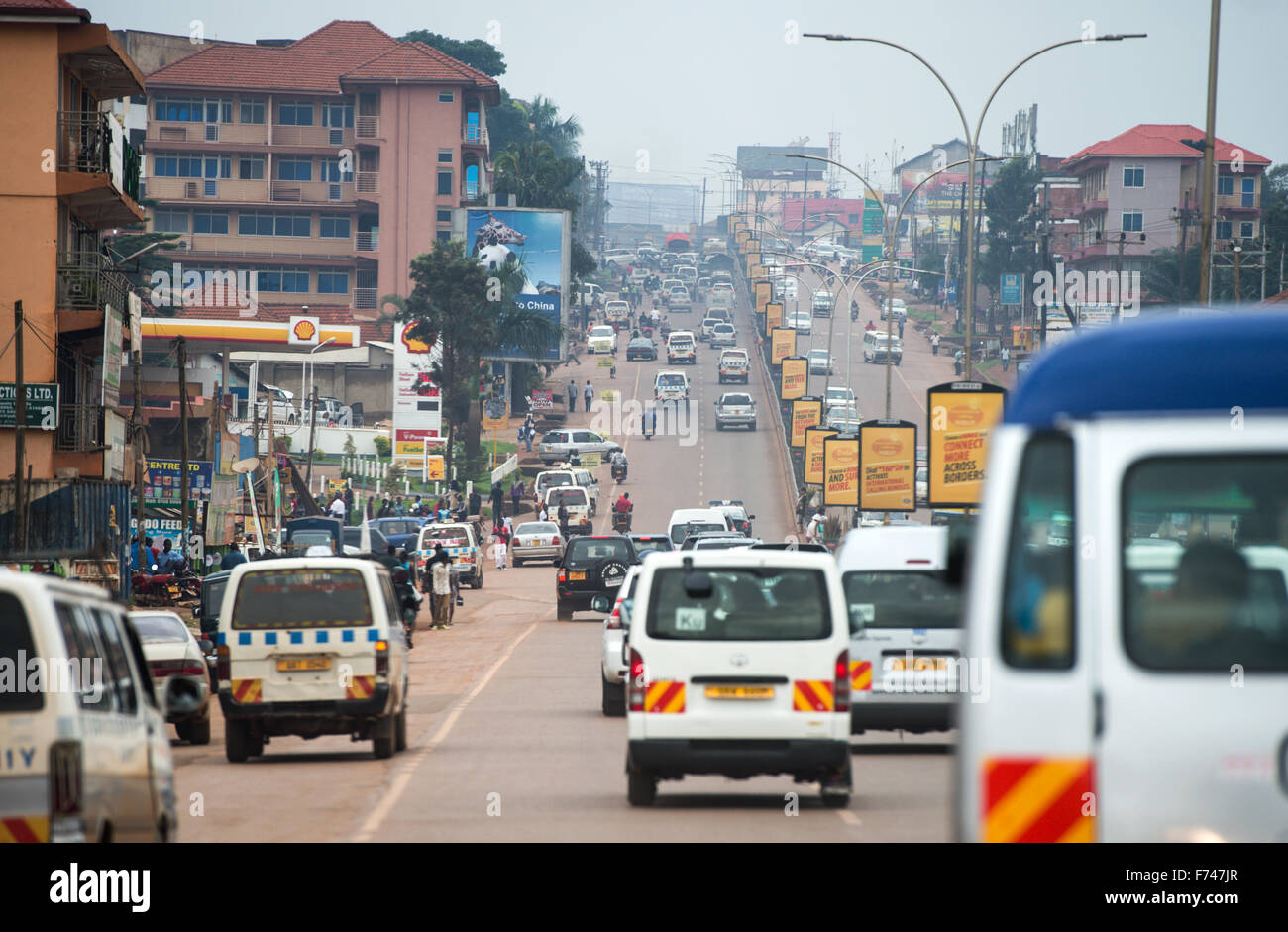 Cars make their way along a street between Kampala and Entebbe, Uganda
