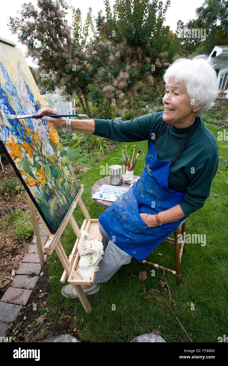 elderly artist painting in garden Stock Photo