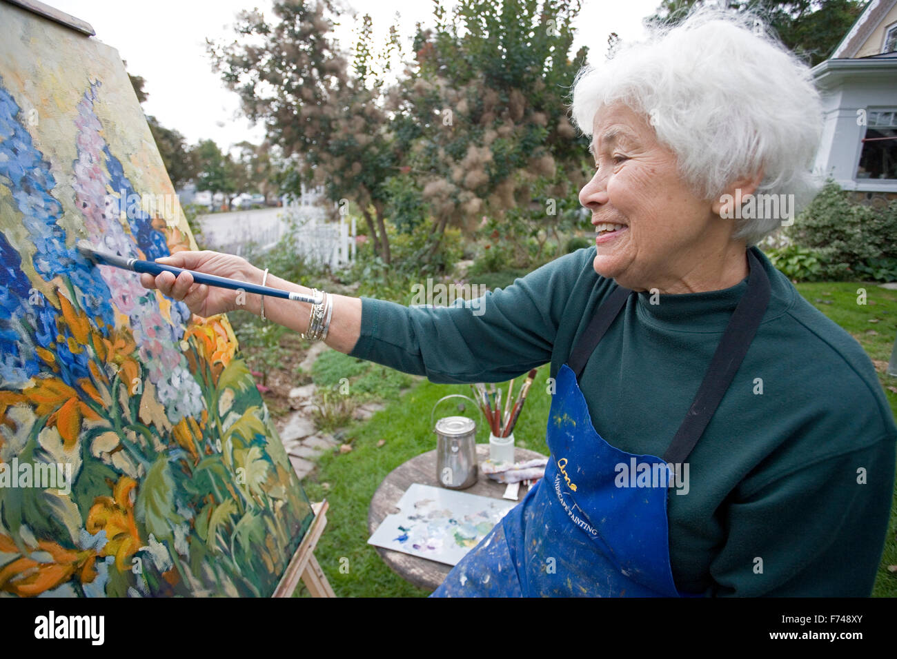 elderly artist painting in garden Stock Photo