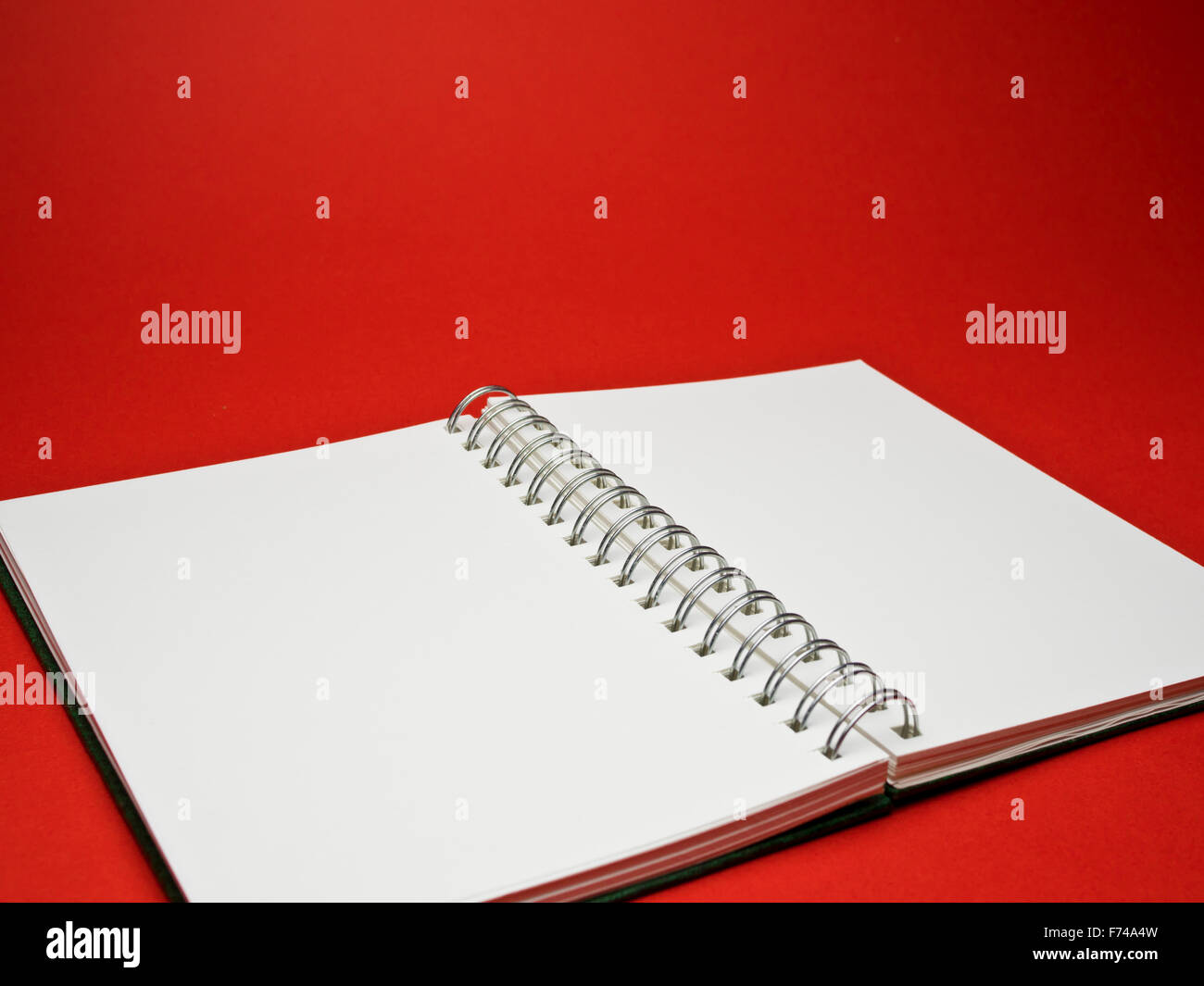 red background with a white sketchbook Stock Photo