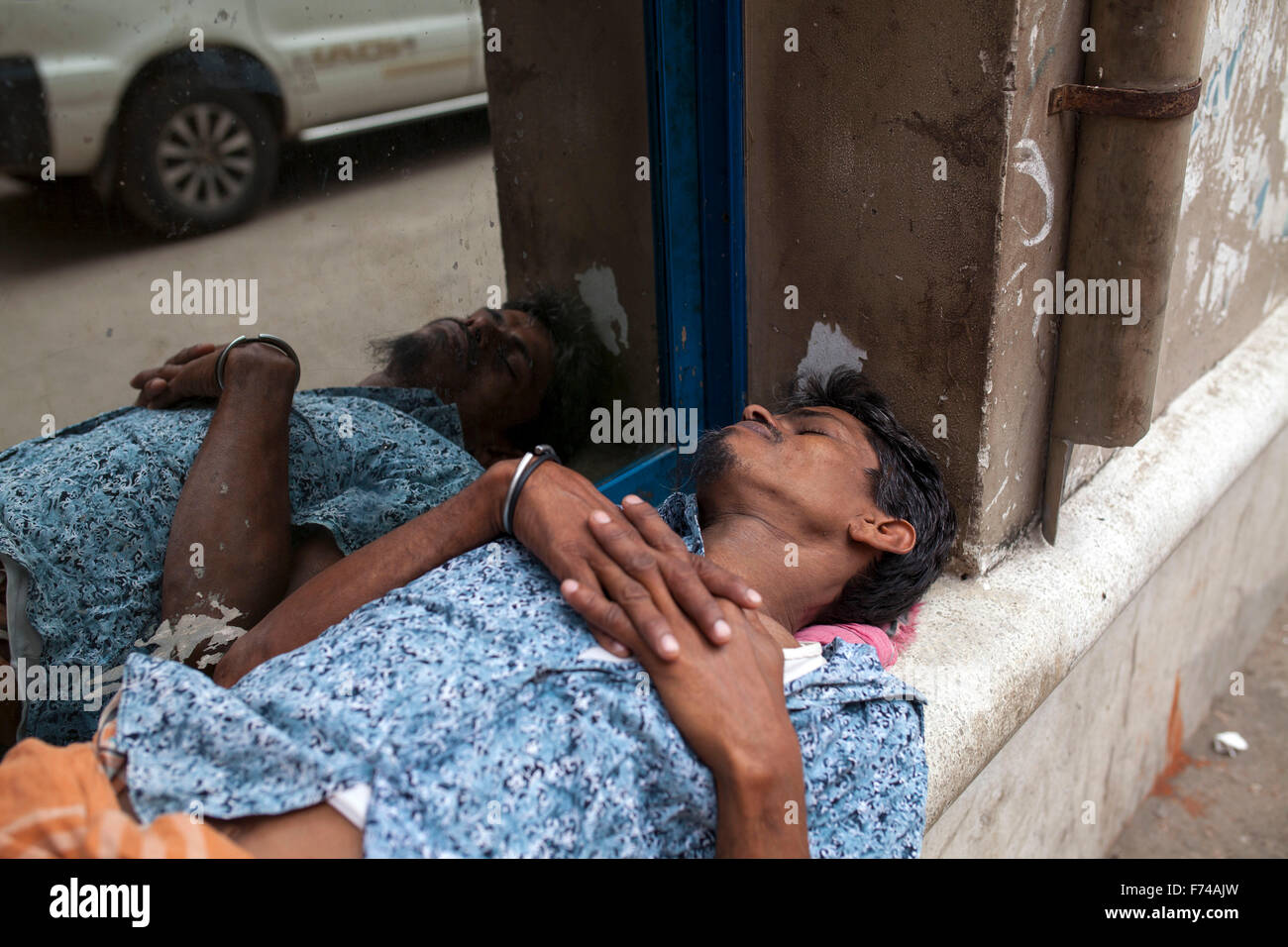 DHAKA, BANGLADESH 17th November: A man sleeping beside road in Old Dhaka on November 17, 2015. Old Dhaka is a term used to refer to the historic old city of Dhaka, the capital of modern Bangladesh. It was founded in 1608 as Jahangir Nagar, the capital of Mughal Bengal. Stock Photo