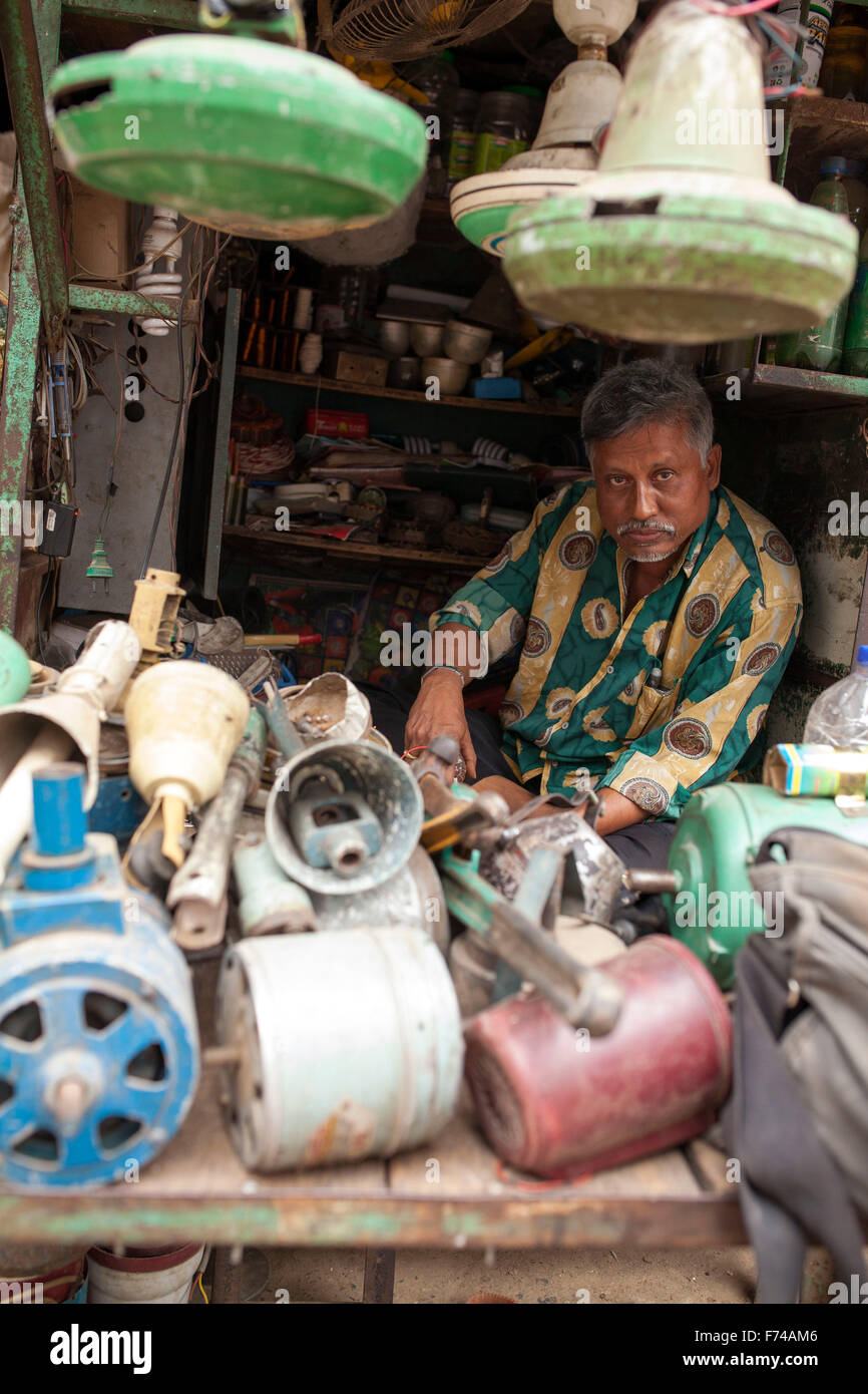 DHAKA, BANGLADESH 17th November: A repair man repairing electrical machinery in his shop in Old Dhaka on November 17, 2015. Old Dhaka is a term used to refer to the historic old city of Dhaka, the capital of modern Bangladesh. It was founded in 1608 as Jahangir Nagar, the capital of Mughal Bengal. Stock Photo