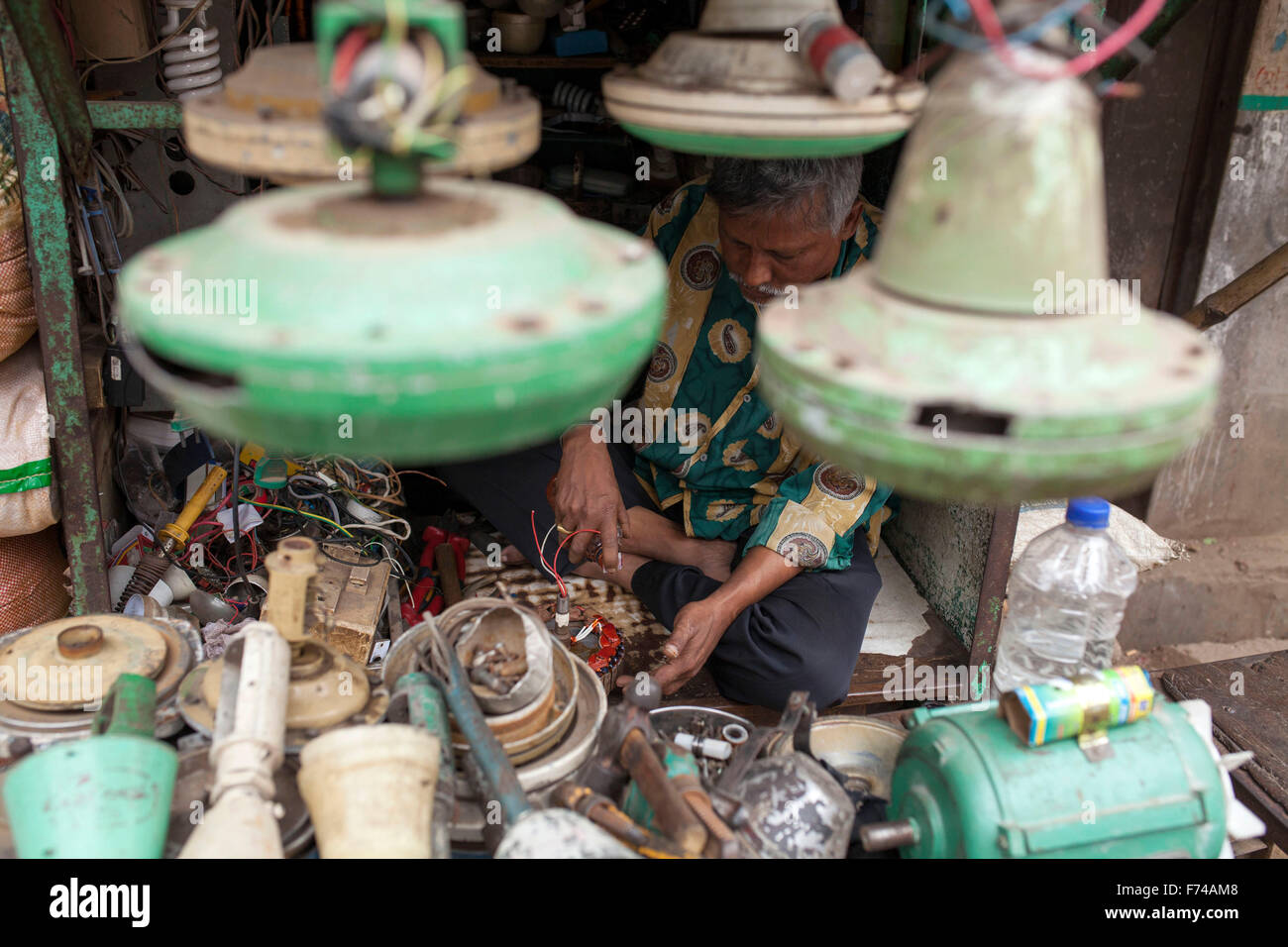 DHAKA, BANGLADESH 17th November: A repair man repairing electrical machinery in his shop in Old Dhaka on November 17, 2015. Old Dhaka is a term used to refer to the historic old city of Dhaka, the capital of modern Bangladesh. It was founded in 1608 as Jahangir Nagar, the capital of Mughal Bengal. Stock Photo