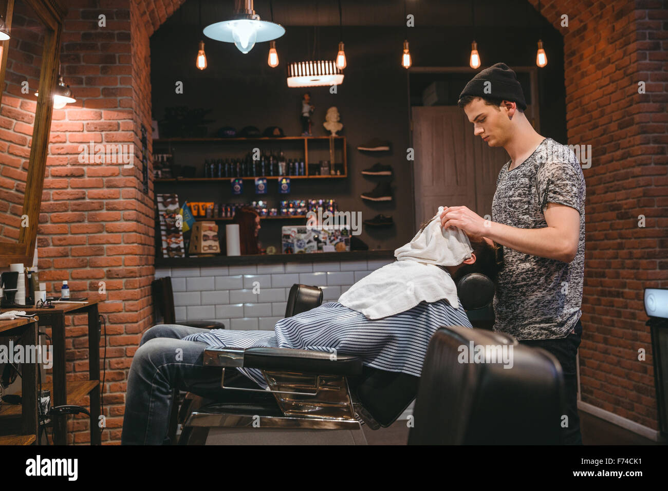 Barber finishing grooming and taking care of client's face in