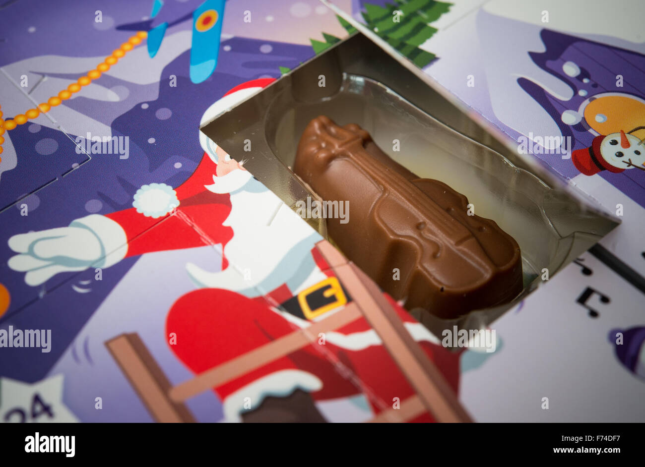 Sieversdorf, Germany. 24th Nov, 2015. A small piece of chocolate pictured next to the an opened door of an Advent calendar in Sieversdorf, Germany, 24 November 2015. Photo: PATRICK PLEUL/dpa/Alamy Live News Stock Photo