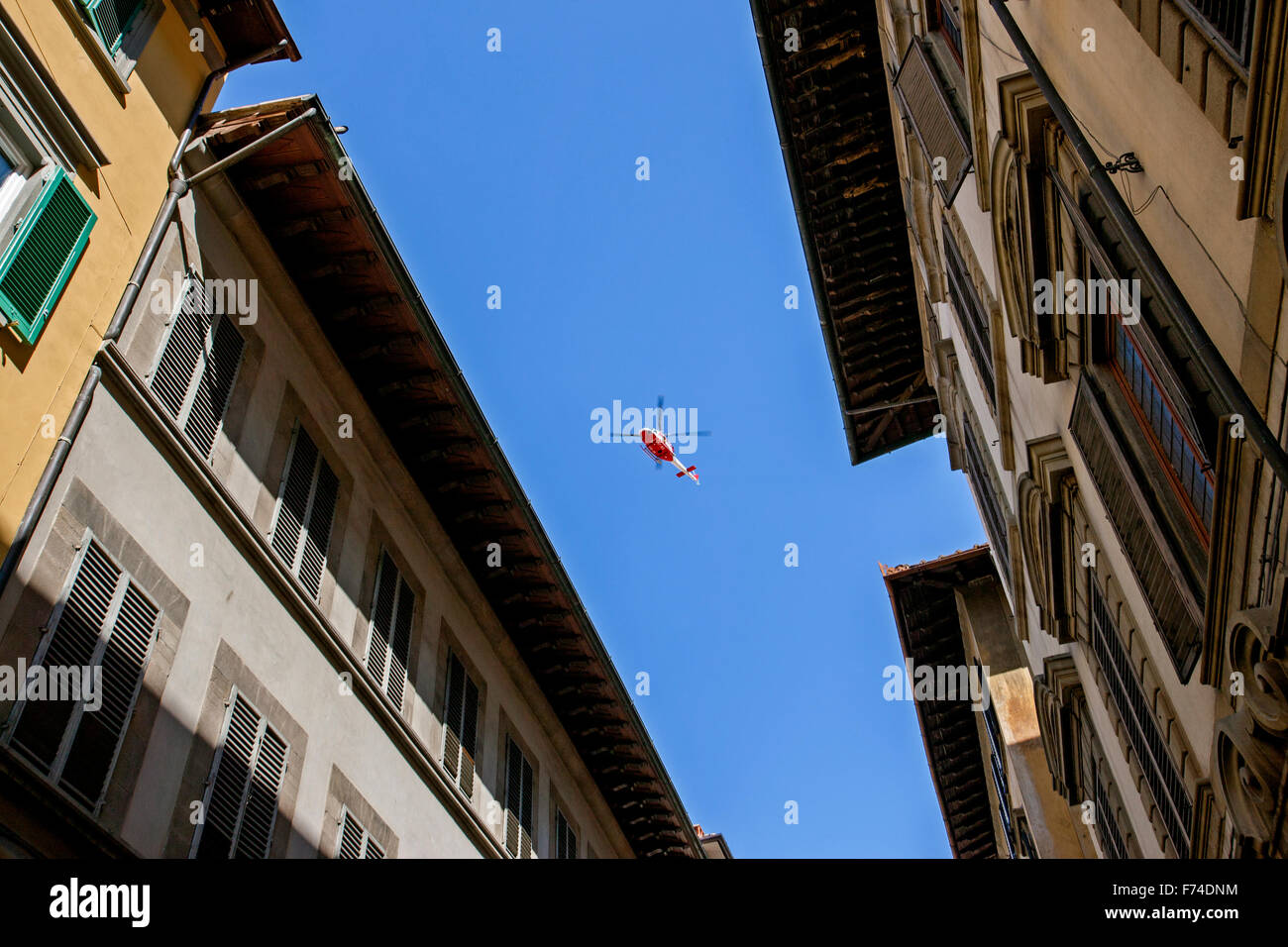 red helicopter in sky over Florence streets Italy Stock Photo