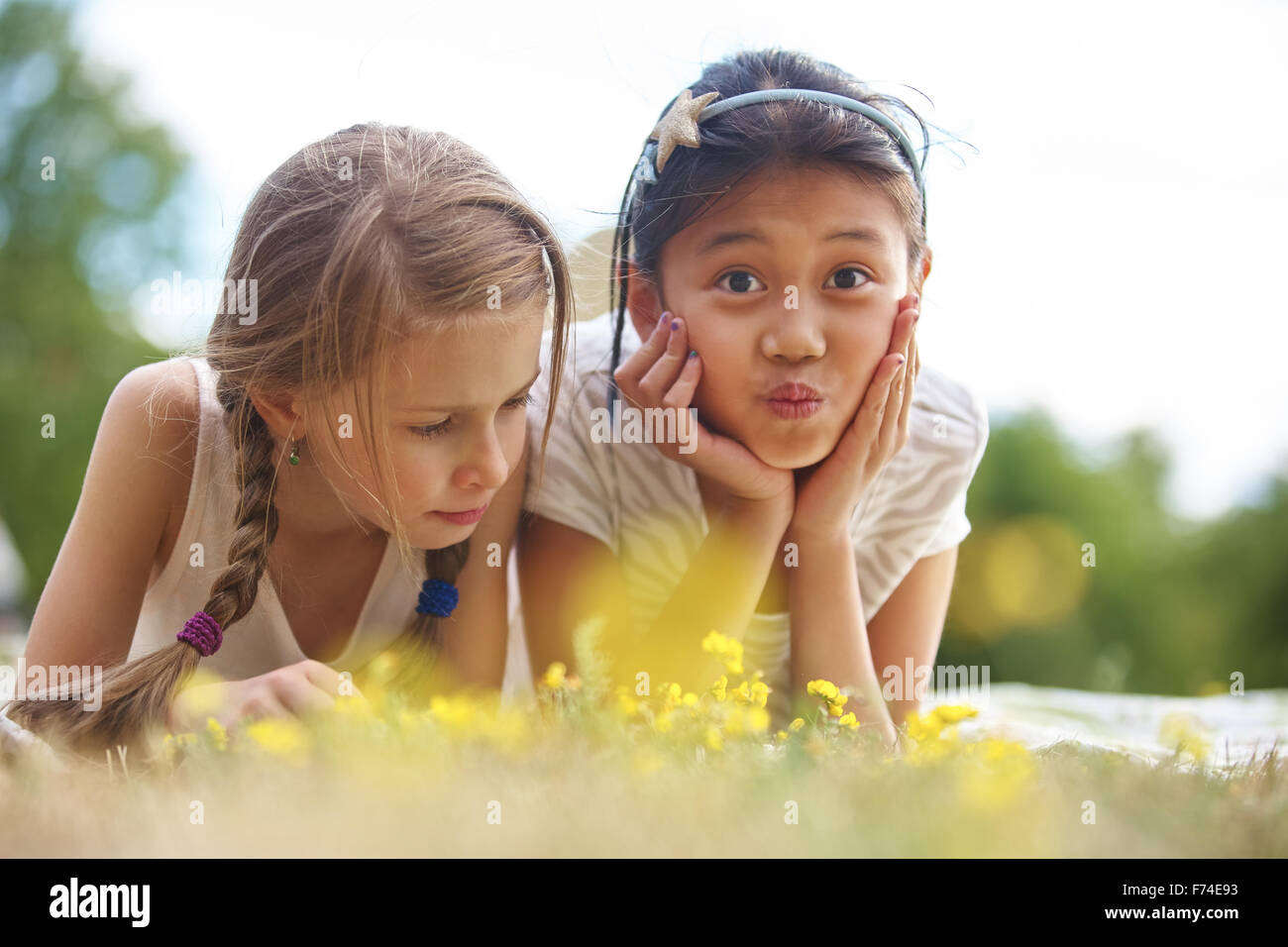 Girl and her friend on the grass making funny faces Stock Photo