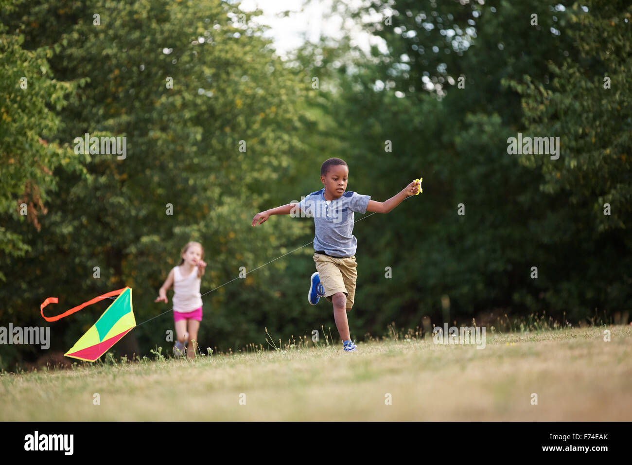 Girl and boy flying a kite in summer Stock Photo