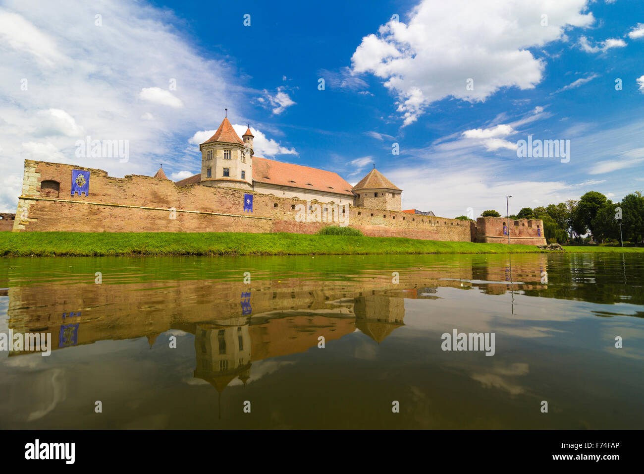 Old castle mirrored by surrounding moat, Transylvania, Romania Stock Photo