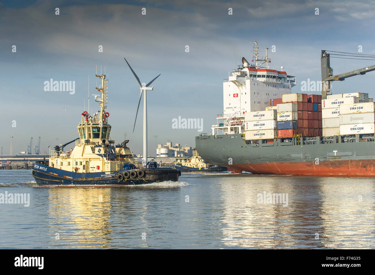 The tug, Svitzer Bootle preparing to escort the container cargo ship, Pomerenia Sky as she leaves the Port of Tilbury on the Riv Stock Photo