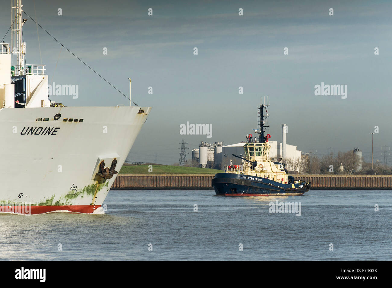 The tug Svitzer Bootle waiting to escort the RO-RO cargo ship, Undine as she steam downriver on the River Thames. Stock Photo
