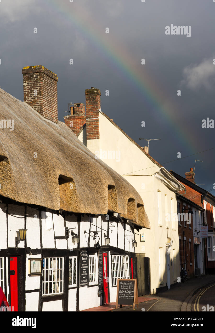 Autumn rainbow over the thatched roof of the Old Cottage restaurant, West Street, Ringwood, New Forest, Hampshire, UK Stock Photo