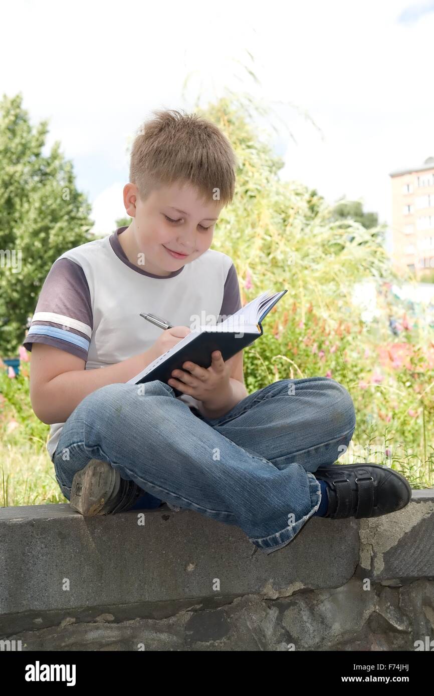 boy writes to writing-books Stock Photo - Alamy