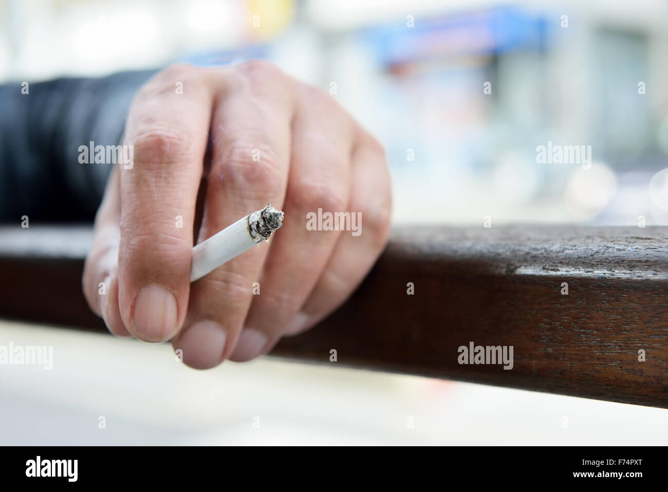 Hand of a man holding a cigarette outdoors Stock Photo