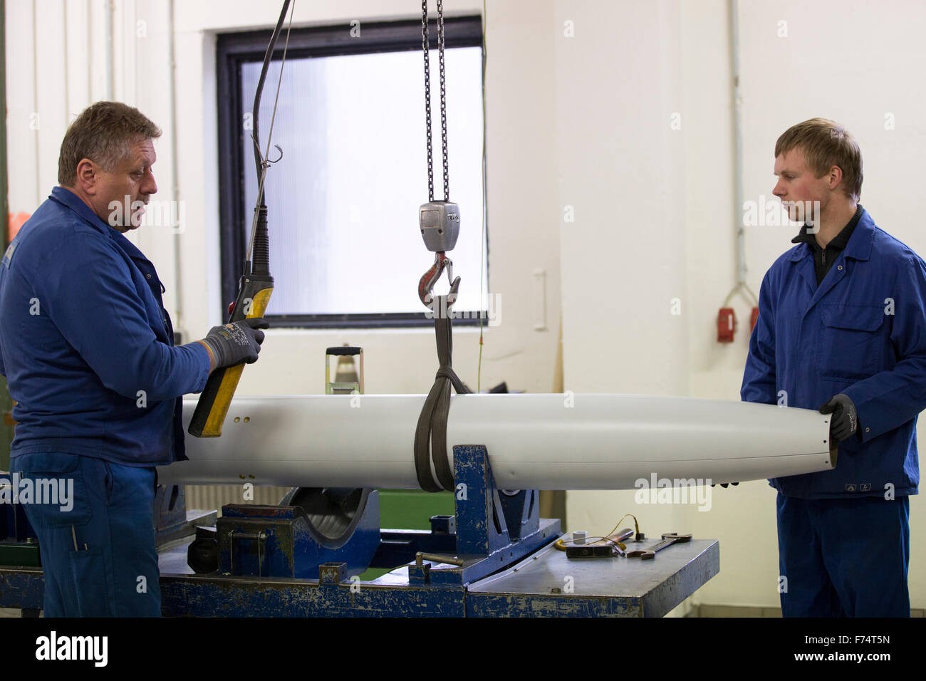 HANDOUT - A handout picture made available on 25 November 2015 by the German armed forces (Bundeswehr) shows employees of the company Nammo Buck GmbH working on the munition of a M26 MLRS multiple missile launcher in Pinnow, Germany, 25 November 2015. Some 25 years after the end of the Cold War, the last batch of cluster munition of the German armed forces has been dismantled. Employees of a munitions disposal company disassembled the remaining missiles in Pinnow. Photo: JANA NEUMANN/Bundeswehr (ATTENTION EDITORS: FOR EDITORIAL USE ONLY IN CONNECTION WITH CURRENT REPORTING/ MANDATORY CREDIT Stock Photo