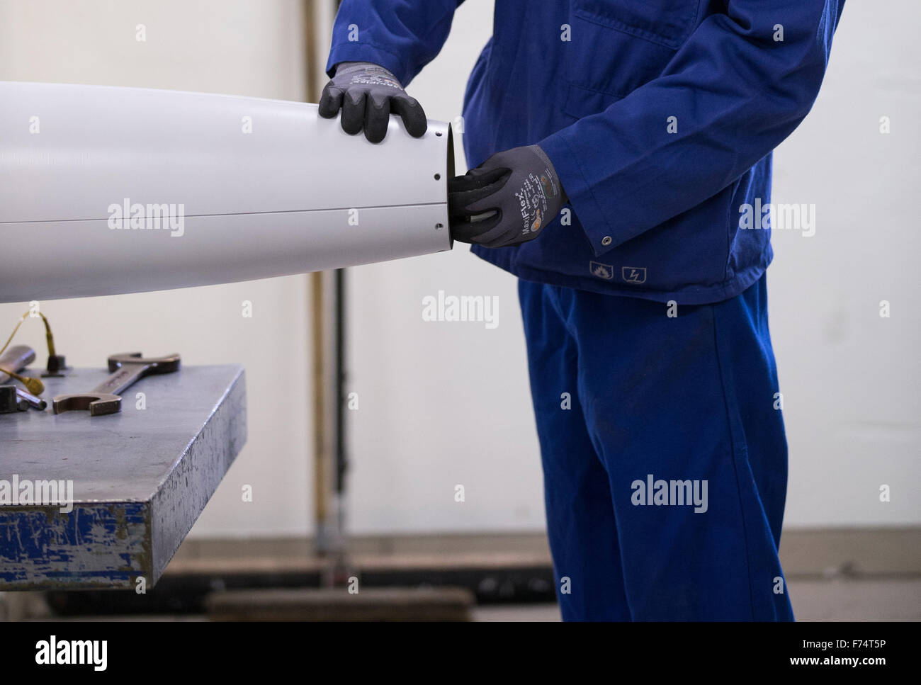 HANDOUT - A handout picture made available on 25 November 2015 by the German armed forces (Bundeswehr) shows an employee of the company Nammo Buck GmbH working on the munition of a M26 MLRS multiple missile launcher in Pinnow, Germany, 25 November 2015. Some 25 years after the end of the Cold War, the last batch of cluster munition of the German armed forces has been dismantled. Employees of a munitions disposal company disassembled the remaining missiles in Pinnow. Photo: JANA NEUMANN/Bundeswehr (ATTENTION EDITORS: FOR EDITORIAL USE ONLY IN CONNECTION WITH CURRENT REPORTING/ MANDATORY CRED Stock Photo