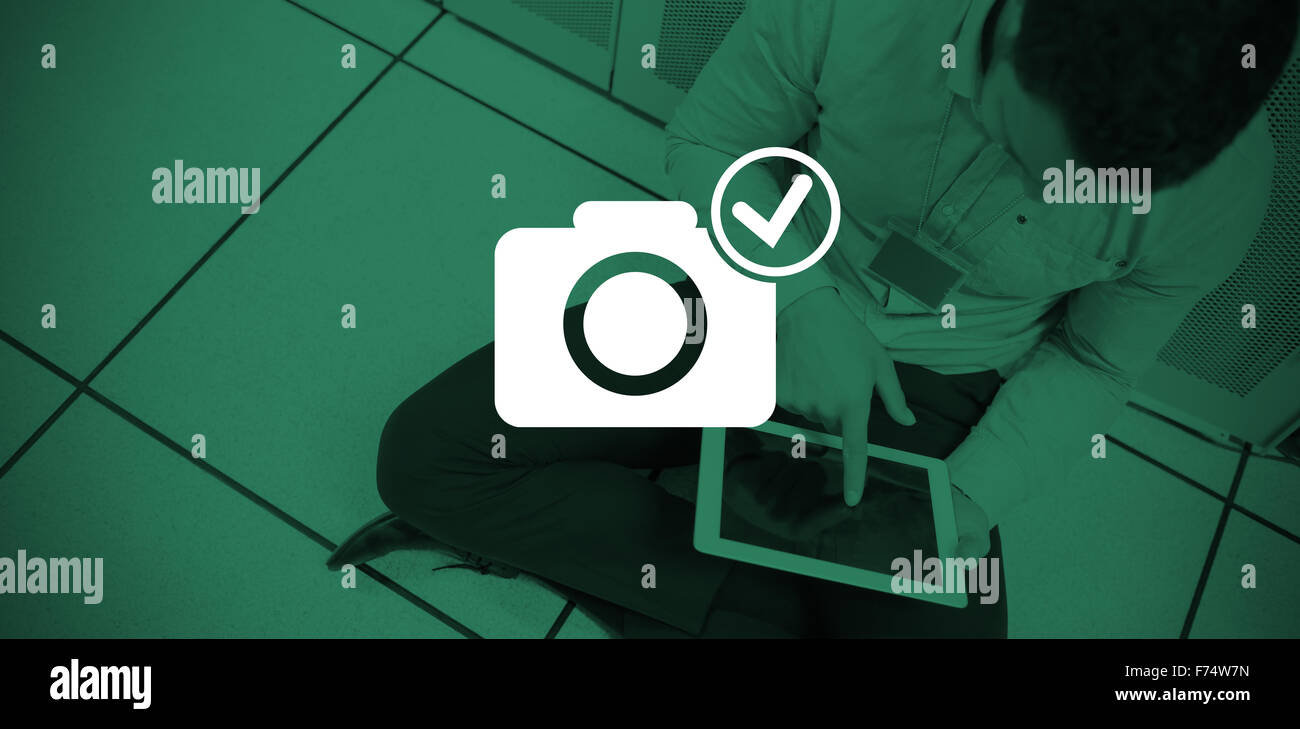Composite image of digitally generated image of camera with tick symbol Stock Photo