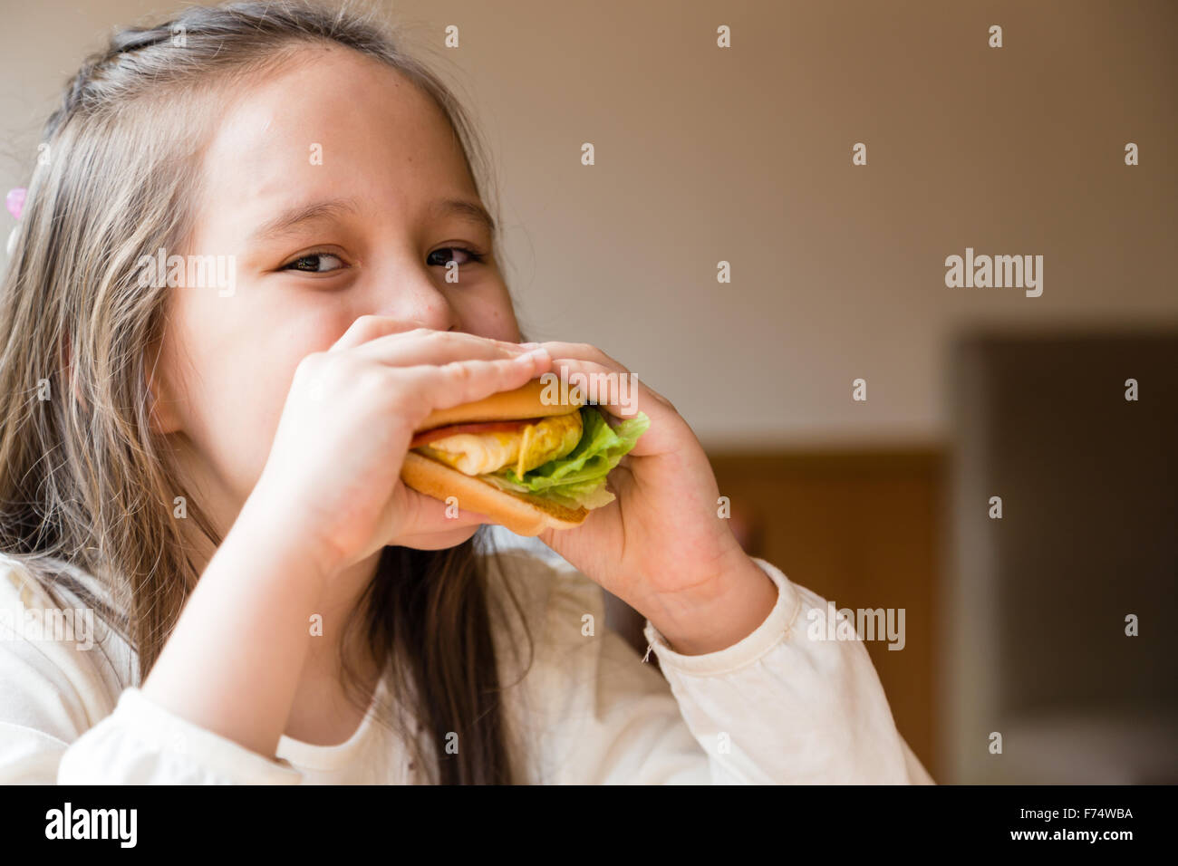 Asian American girl eating burger Stock Photo