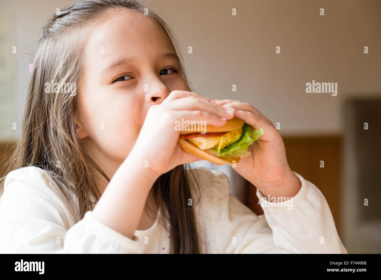 Asian American girl eating burger Stock Photo