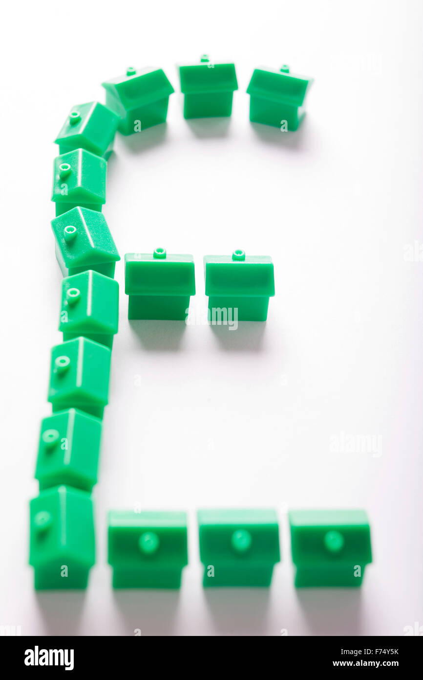 Green model houses in shape of sterling symbol Stock Photo