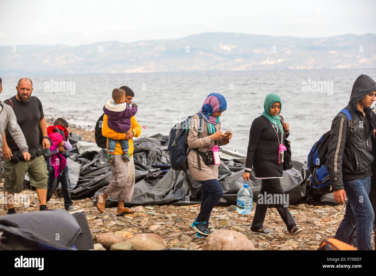 Syrian migrants fleeing the war and escaping to Europe, landing on the Greek island of Lesvos on the north coast at Efthalou. Up to 4,000 migrants a day are landing on the island and overwhelming the authorities. They are traficked by illegal Turkish people traffickers who charge up to $2,000 per person for a half hour ride in an overcrowded inflateable boat from the Turkish mainland to Lesvos. Stock Photo