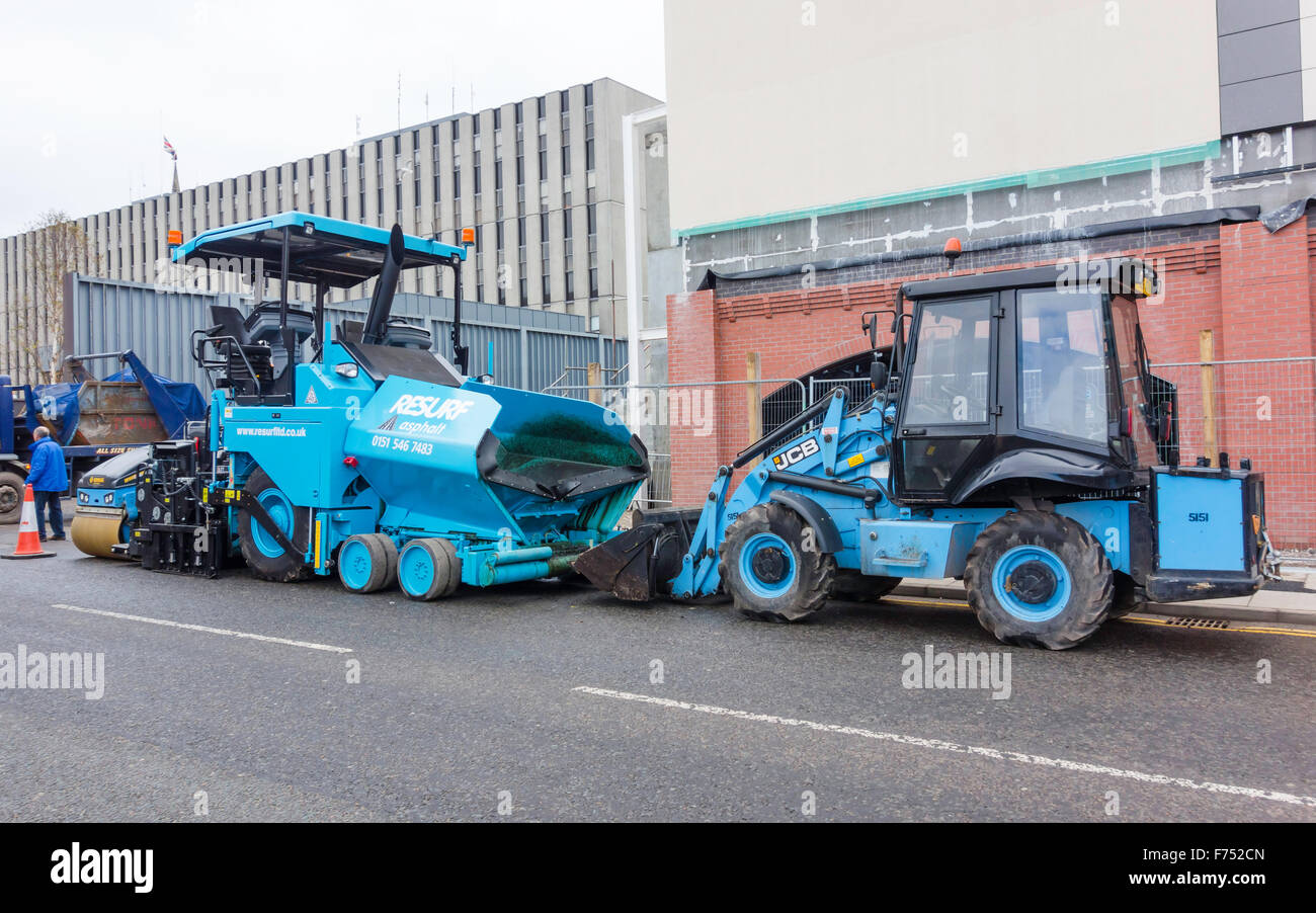 A pavior machine a front end loader and a Bomag Roller equipment for laying a tarmac road resurfacing job Stock Photo