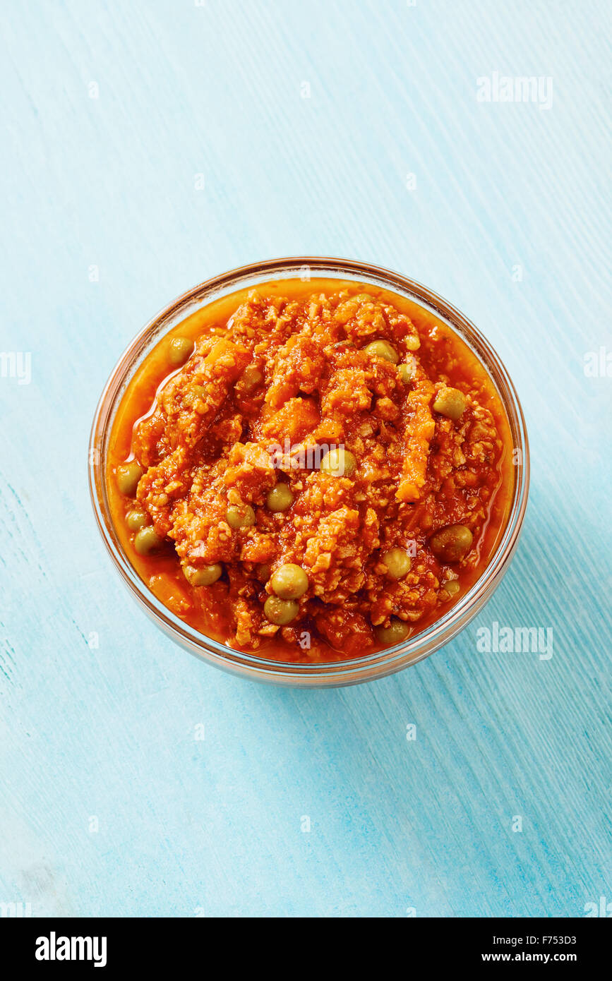 Bolognese sauce in glass bowl on blue table Stock Photo