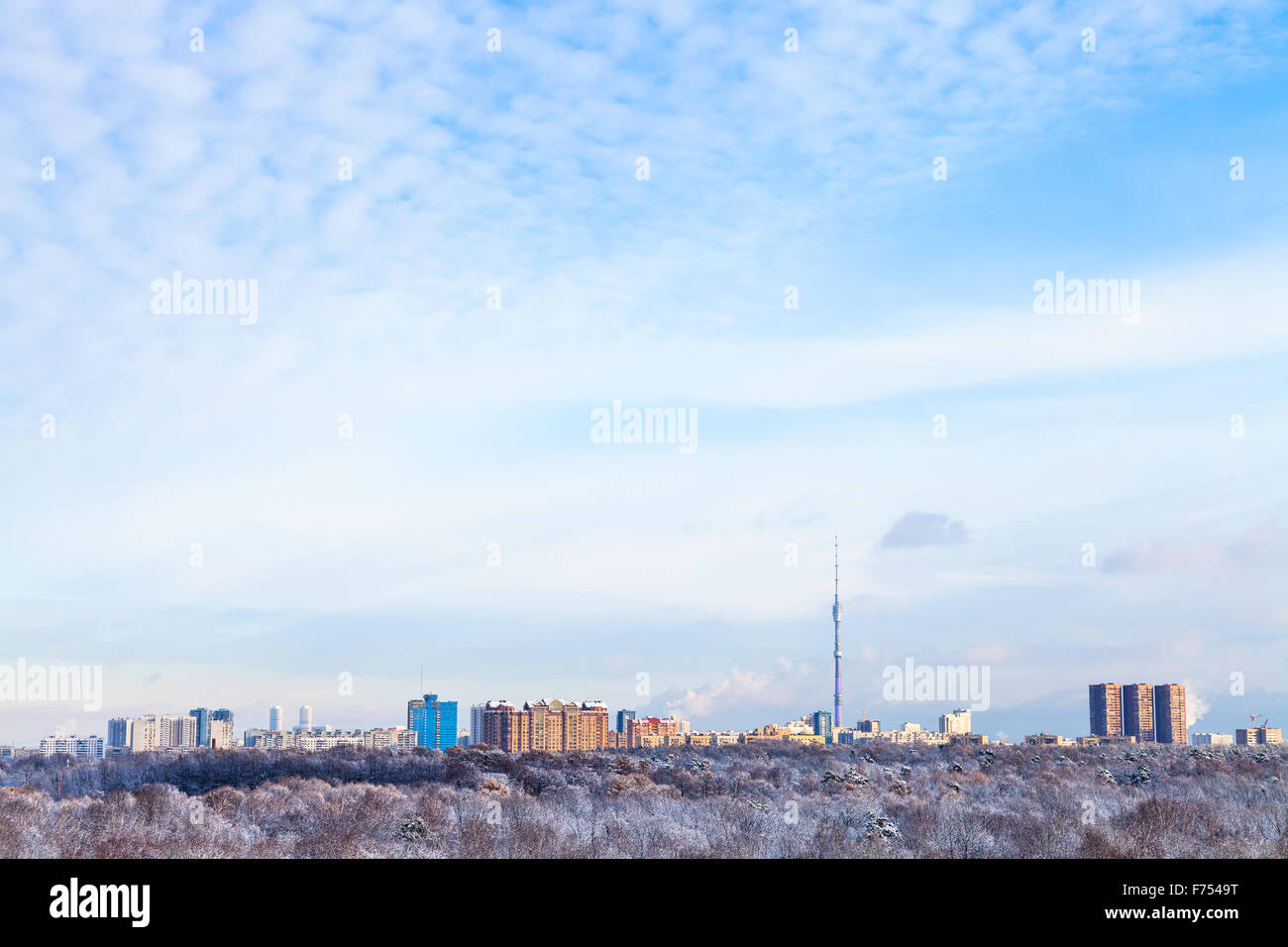 blue sky with white clouds over urban houses and TV tower illuminated ...