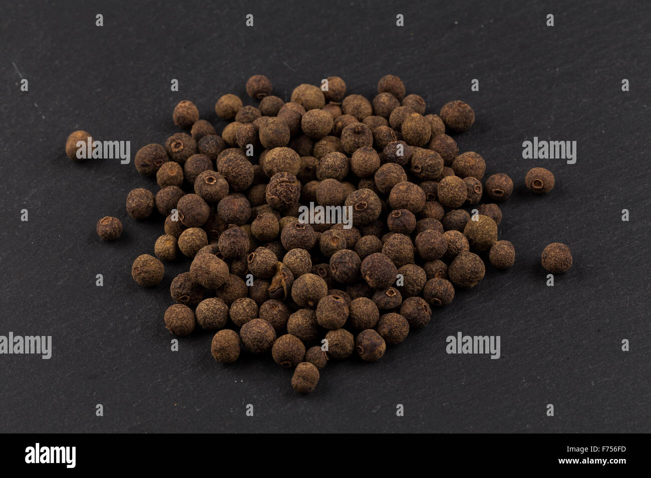 Large black peppercorn seeds on dark stone background Stock Photo Alamy