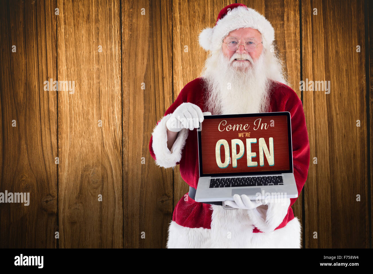 Composite image of santa claus presents a laptop Stock Photo - Alamy