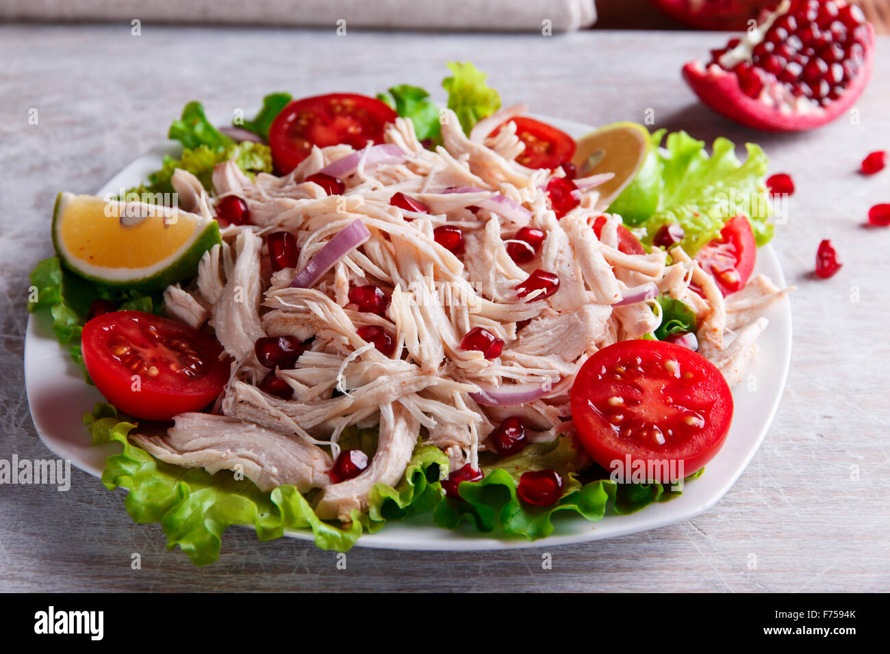 salad of white chicken meat with tomato and pomegranate seeds Stock Photo