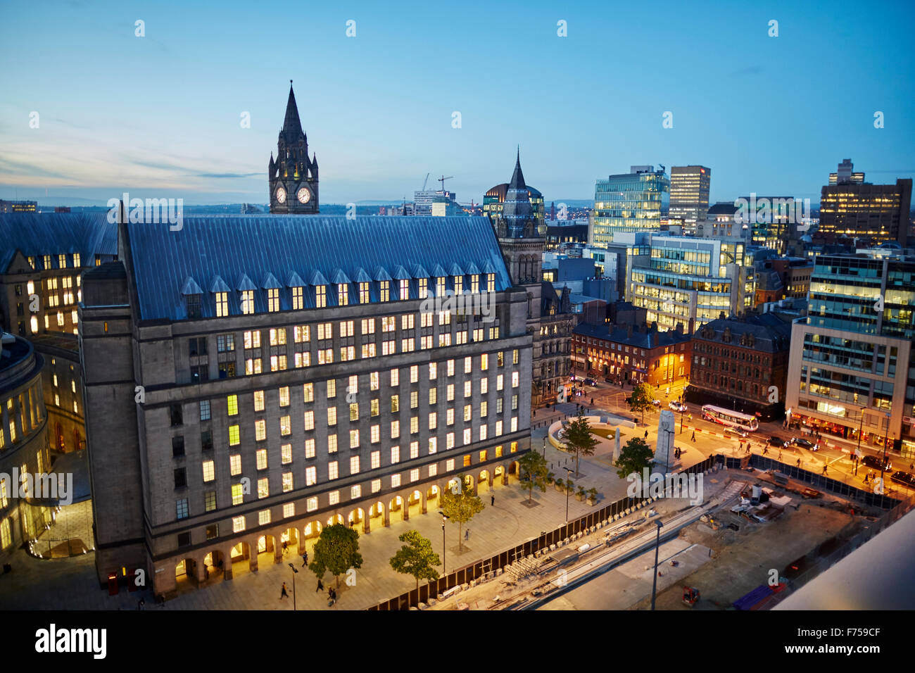 Manchester skyline showing the rooftops and central library and the town hall extension tower light shaft rays through clouds Stock Photo