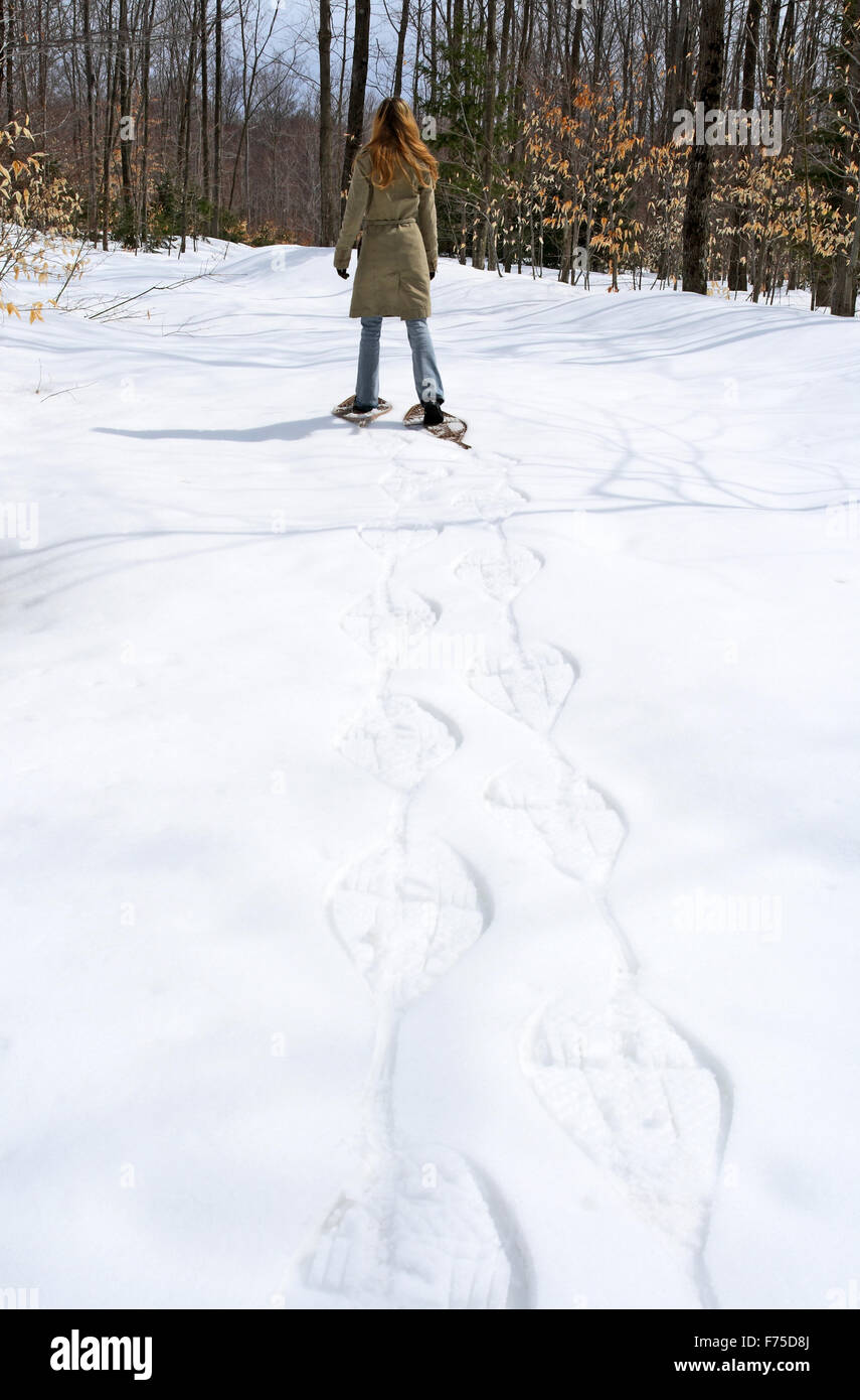 Woman walking in snow shoes in the forest Stock Photo