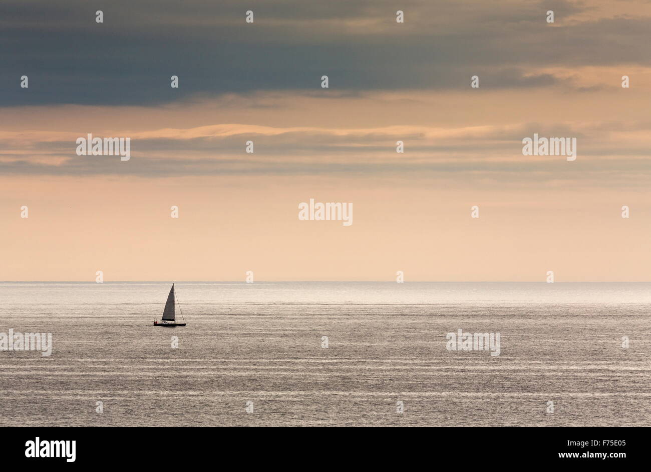 Lone sailing boat at sunset, in the Gulf of St Lawrence, off Newfoundland. Stock Photo