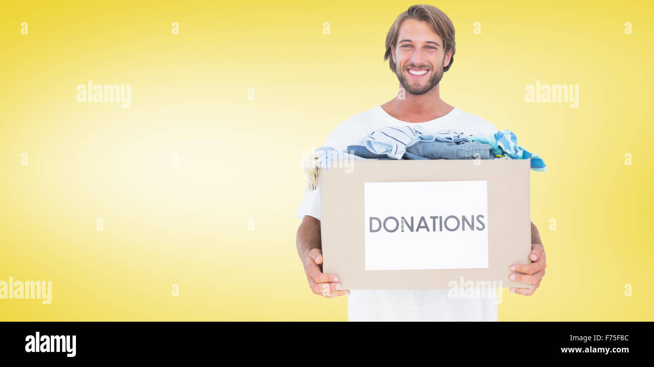 Composite image of happy man carrying donation box Stock Photo