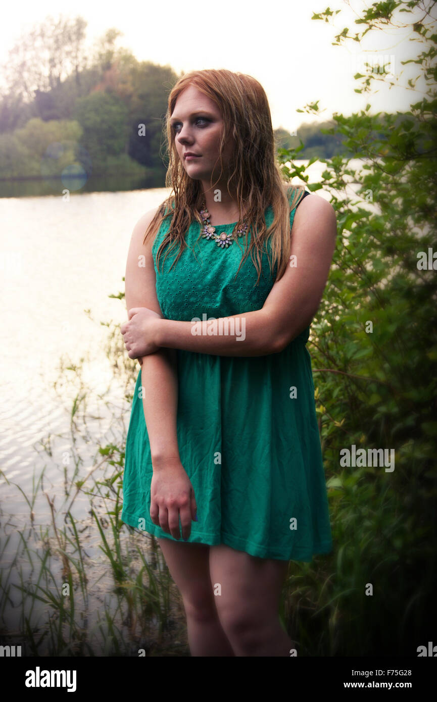 Girl dressed in green with wet hair coming out of the water Stock Photo