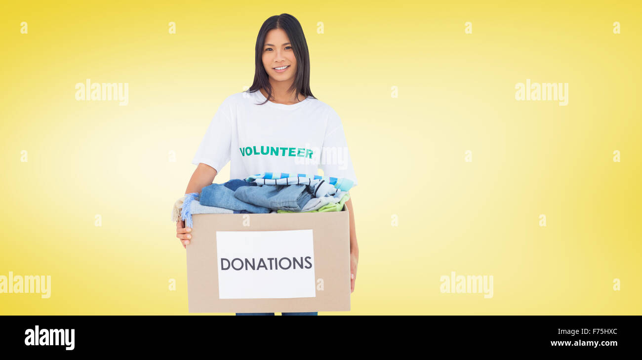 Composite image of happy woman carrying donation box Stock Photo
