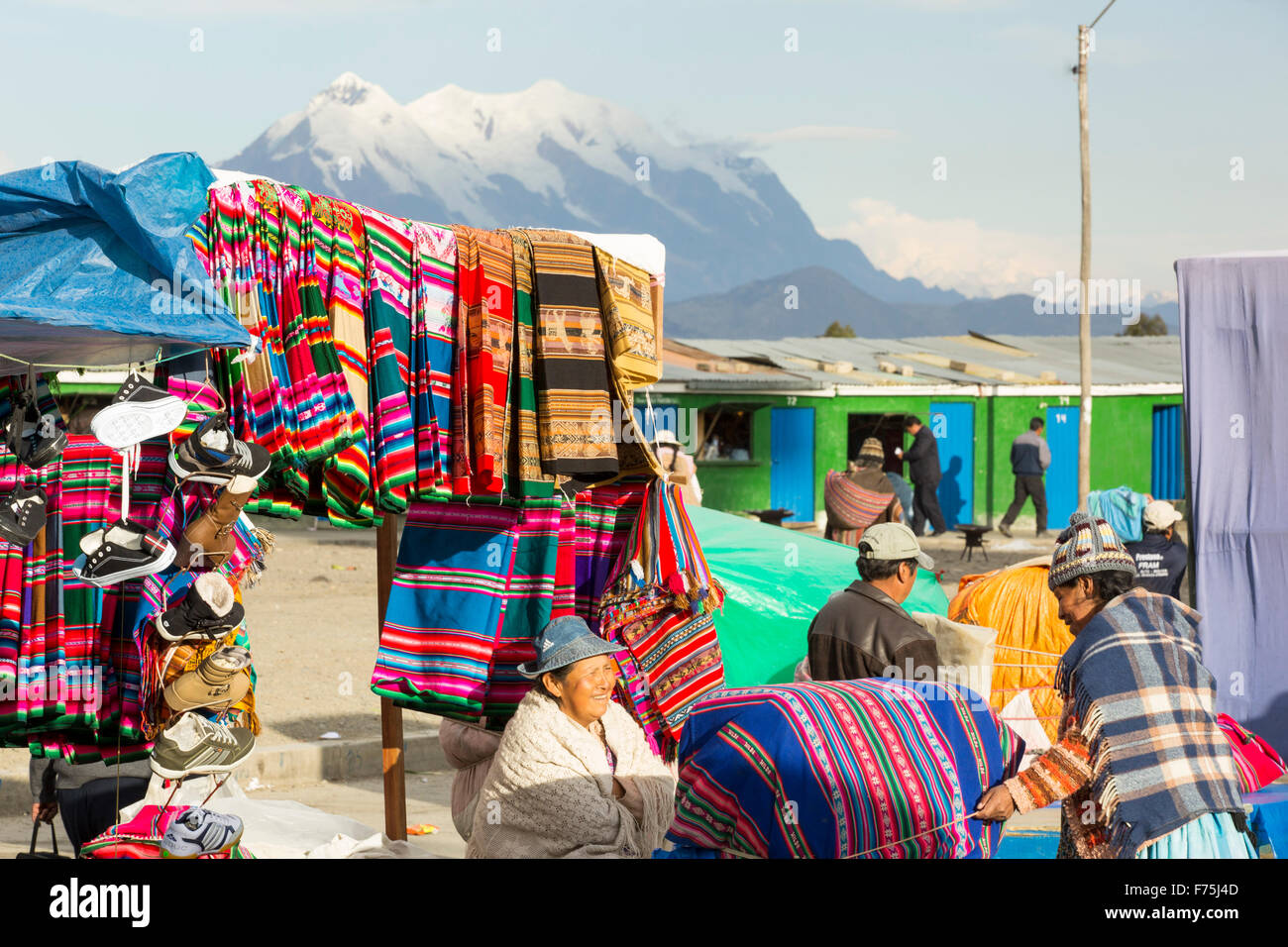 An indigenous woman selling traditional colourful bolivian fabric at a