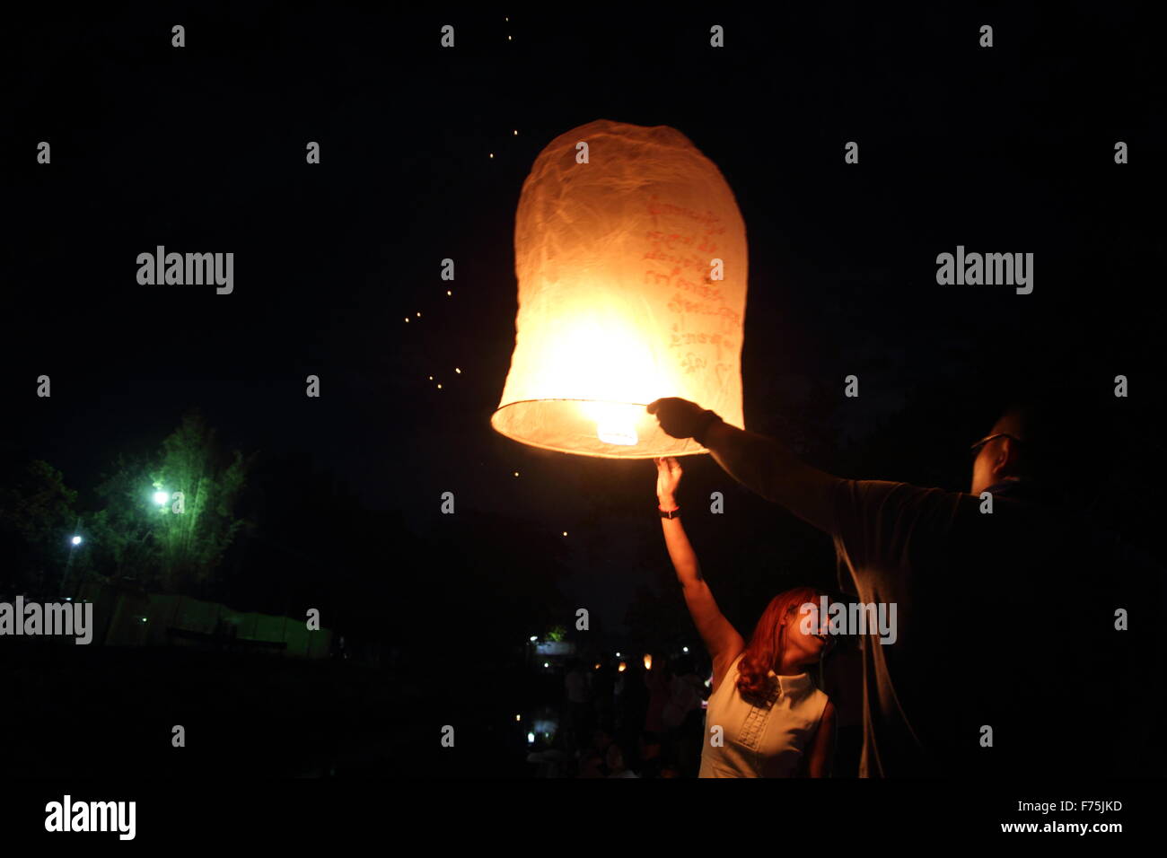 Chiang Mai, Thailand. 25th November 2015. Tourists gather to release Khom Loi (sky lantern) during the Yi Peng Festival outside the Lanna Dhutanka Temple in Chiang Mai. The Lanna Kathina Ceremony takes place around the Loy Krathong festival each year. Stock Photo