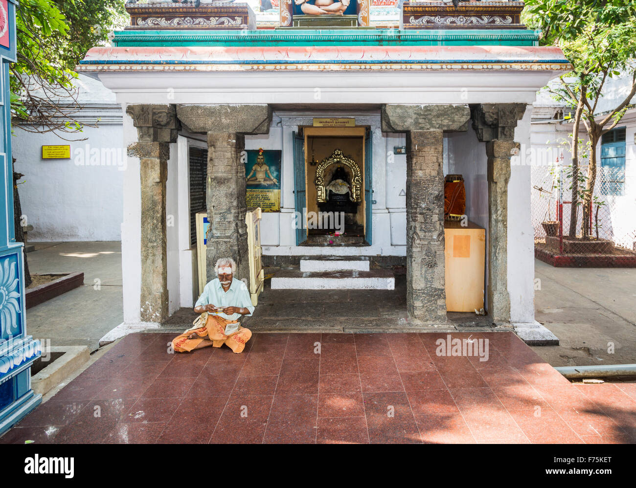 Sadhu holy man sitting outside a shrine in Kapaleeswarar Temple, a Hindu temple of Shiva located in Mylapore, Chennai, Tamil Nadu, south India Stock Photo
