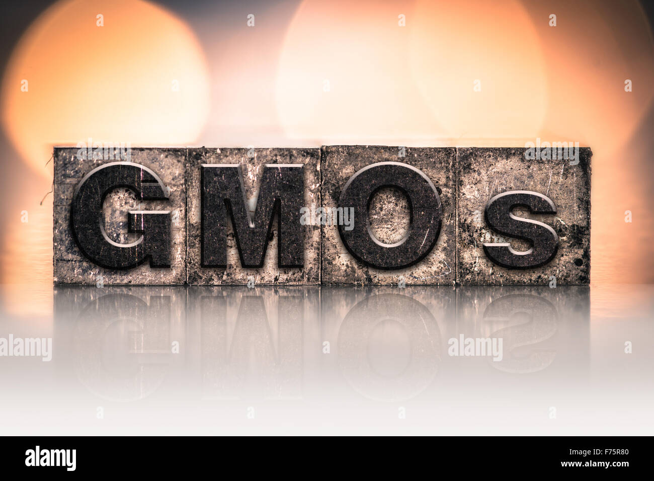 The word "GMOs" written in vintage ink stained letterpress type. Stock Photo