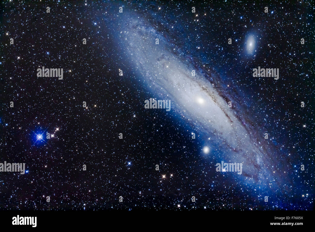 M31, the Andromeda Galaxy, with its companion galaxies, M32 (below) and M110 (aka NGC 205, above), framed to include the blue st Stock Photo