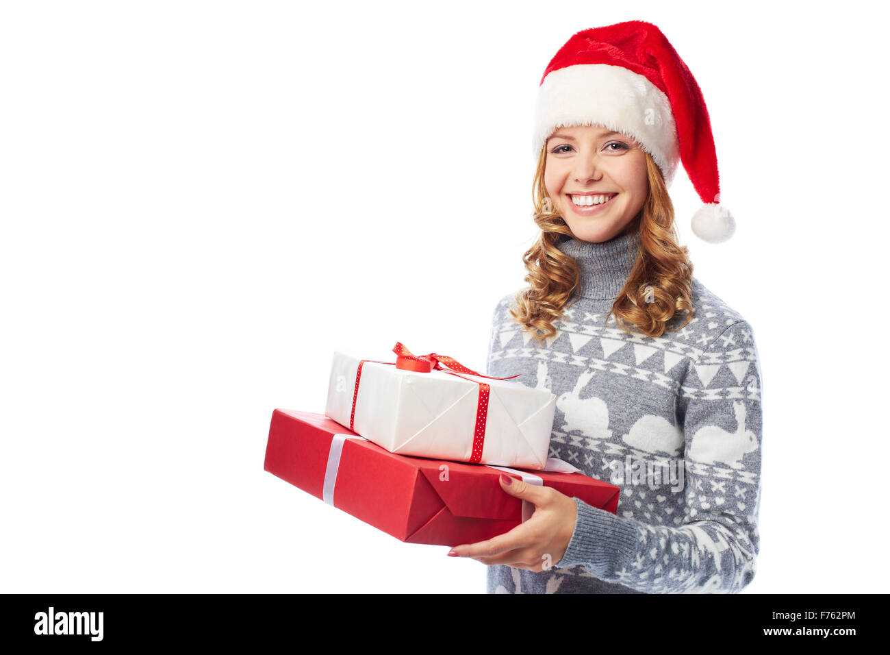 Smiling woman in Santa hat holding gift boxes Stock Photo - Alamy