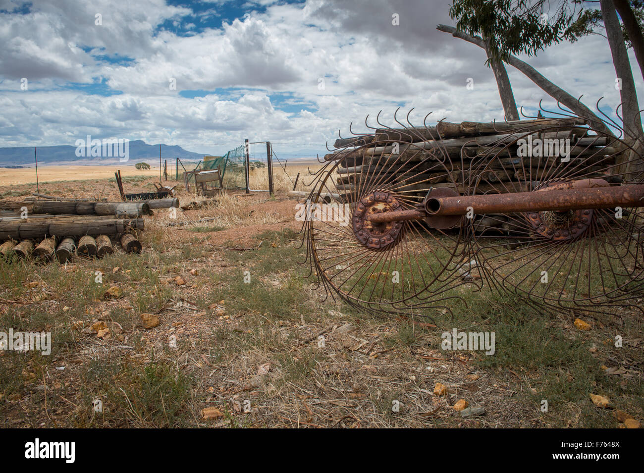 Logs and rusted agricultural equipment on a farm in South Africa Stock