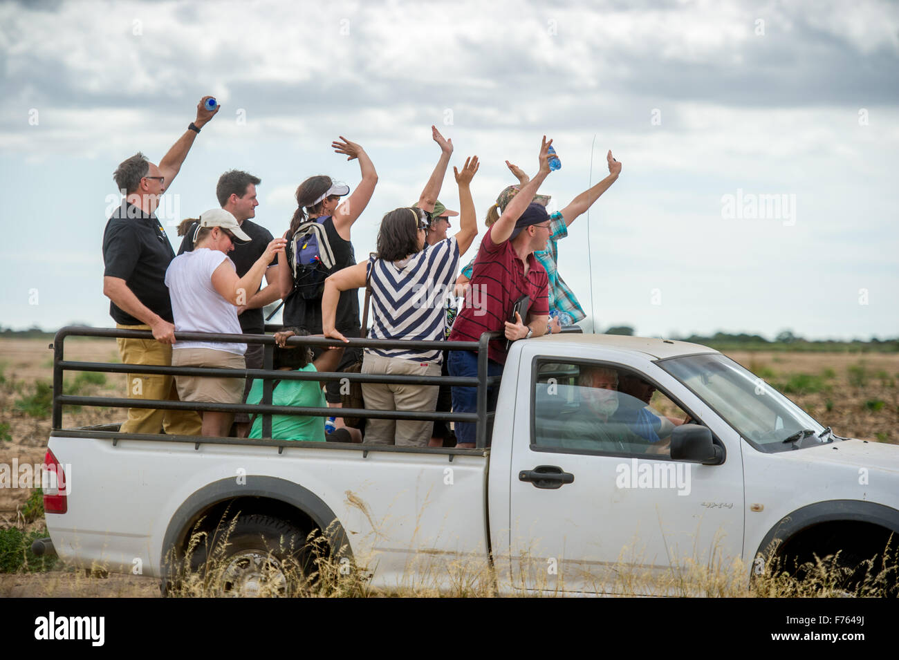 People waving while standing in the back of a pickup truck in South Africa Stock Photo