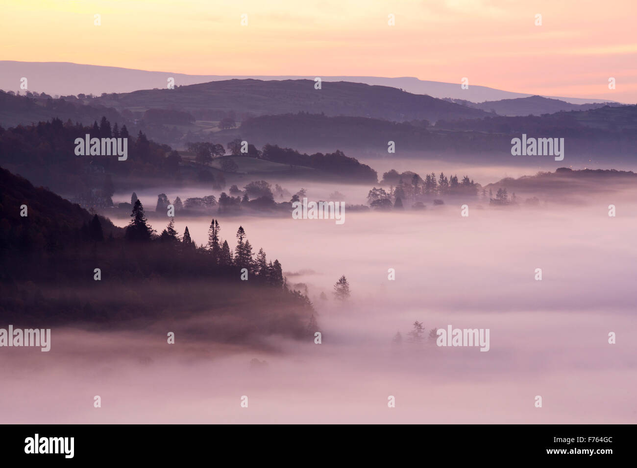 Valley mist over Lake Windermere from Todd Crag in the Lake District, UK at dawn. Stock Photo