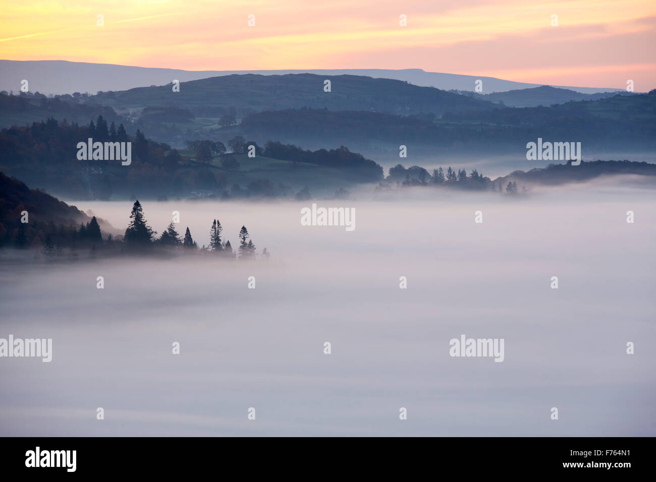 Valley mist over Lake Windermere from Todd Crag in the Lake District, UK at dawn. Stock Photo