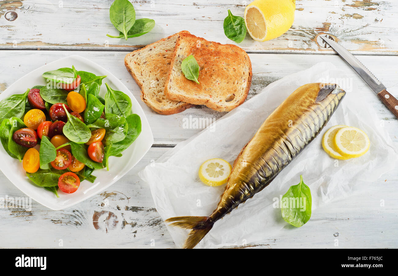 Smoked mackerel with lemon, toast and healthy salad. Top view Stock
